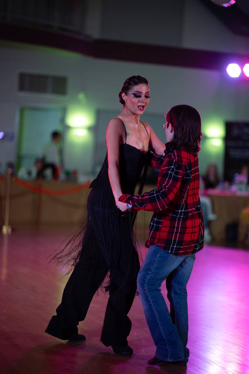 Dance partners sharing a joyful moment on the event floor