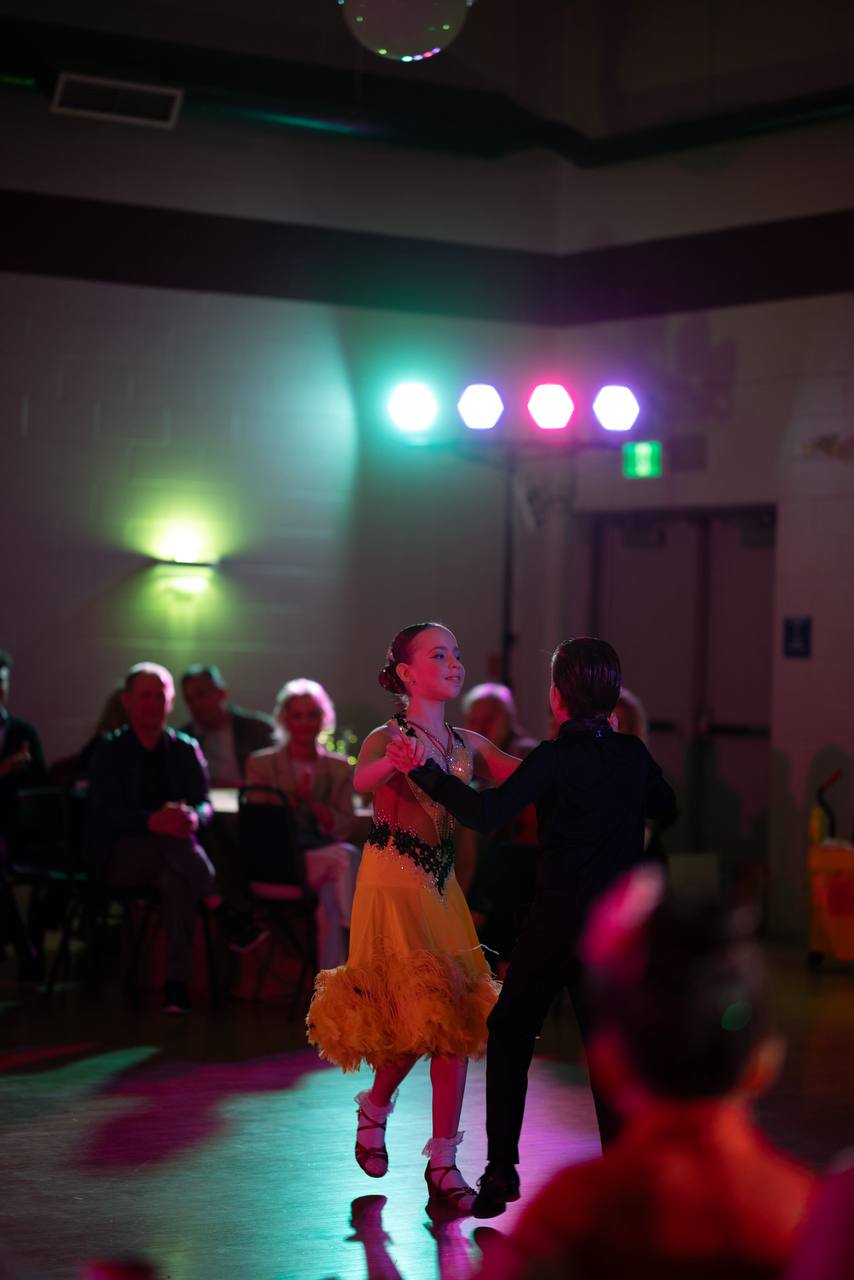 Young ballroom partners dancing before an audience