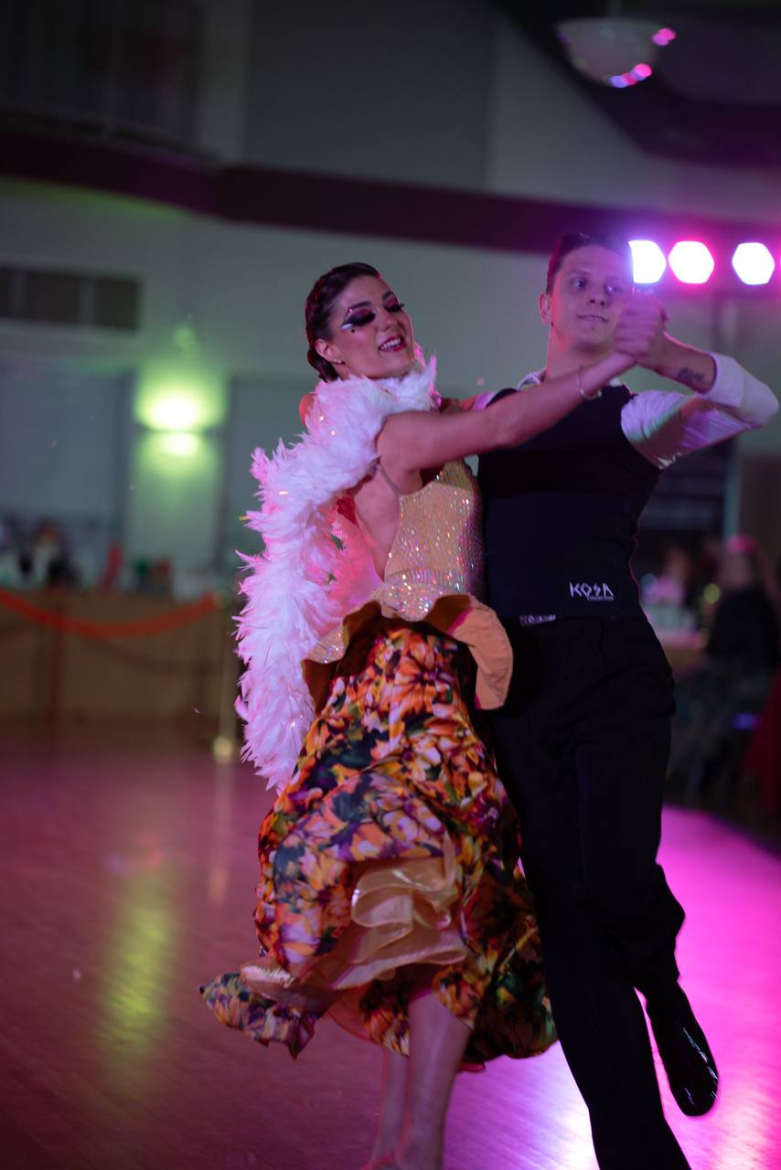 Ballroom couple performing in formal competition attire